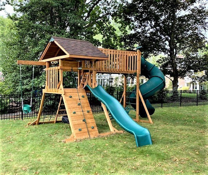 Wooden custom playset in a grassy backyard