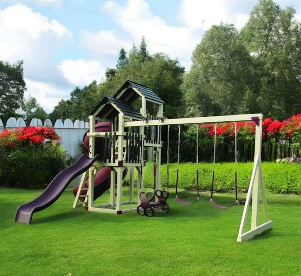 306 Premium Vinyl Backyard Plastion swing set in Backyard with green grass blue sky and red flowers.